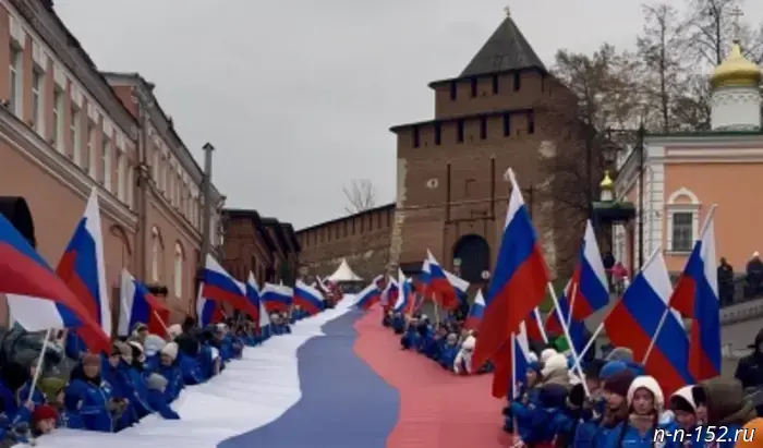 В День народного единства 600 жителей Нижнего Новгорода развернули 100-метровый российский флаг у стен Кремля.